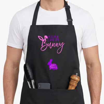 Pregnancy easter bunny aprons - Pink and purple bunny silhouettes with MAMA and BABY Bunny typography — shown on a black cotton canvas apron against a white background