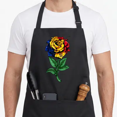 Funny romania romanian apron - Cartoon rose with yellow blue red petals and coat of arms on green stem — shown on a black cotton canvas apron against a white background