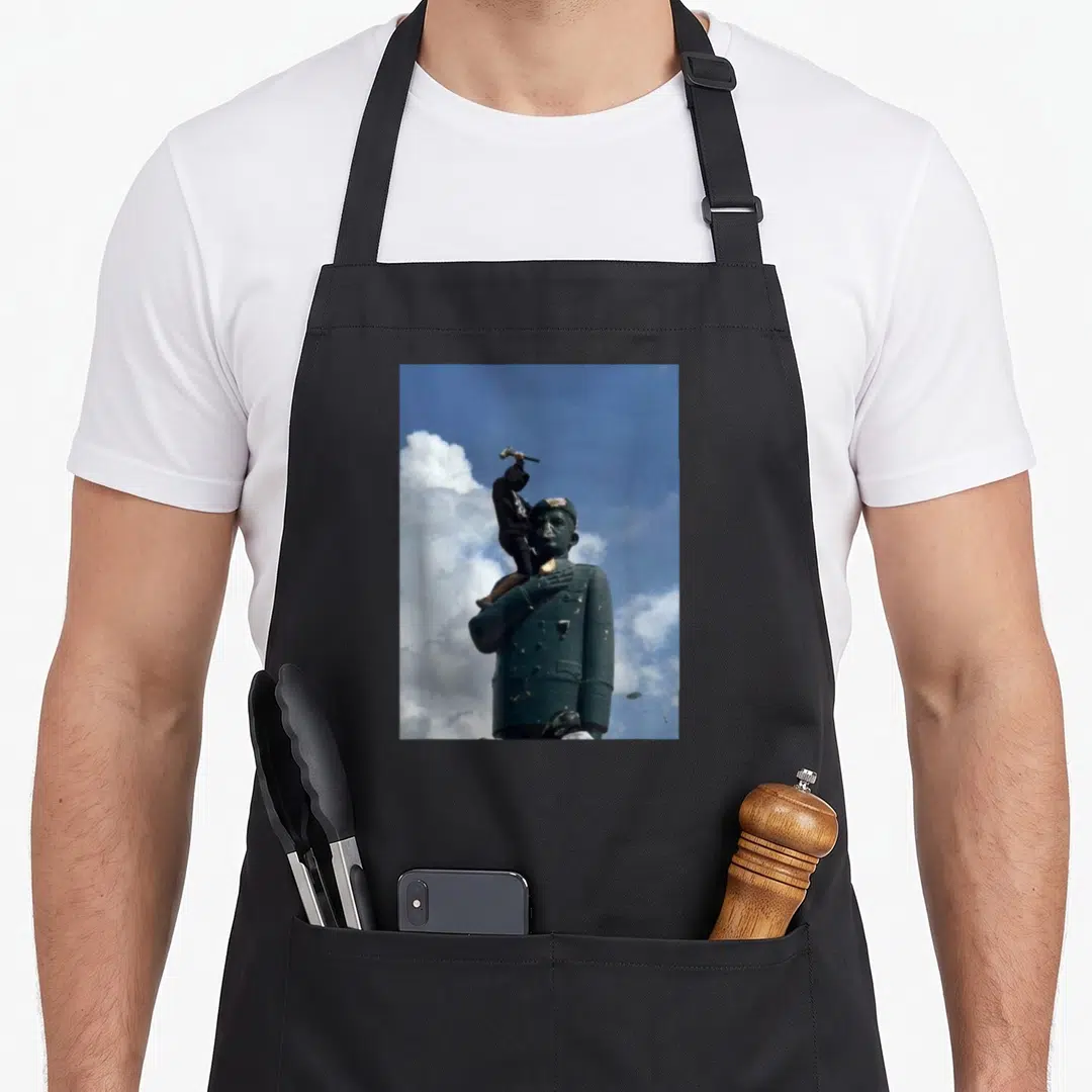 Venezuela venezuelan apron - Photo of dark green statue with person in black standing on shoulder holding hammer — shown on a black cotton canvas apron against a white background