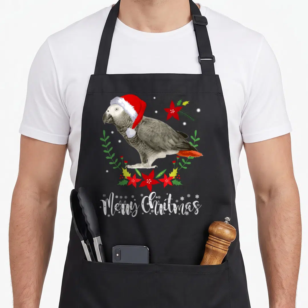 Christmas african aprons - Grey parrot in red santa hat surrounded by poinsettia wreath and Merry Christmas text — shown on a black cotton canvas apron against a white background