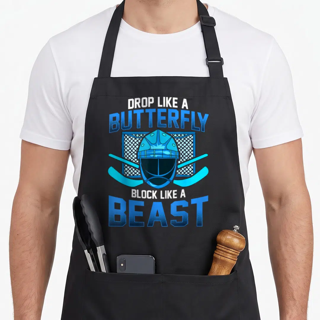 Ice block & apron - Blue goalie mask over net and crossed sticks with text DROP LIKE A BUTTERFLY BLOCK LIKE A BEAST — shown on a black cotton canvas apron against a white background