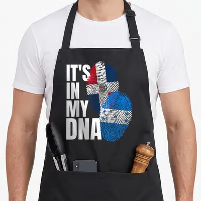 Honduran dominican heritage aprons - IT'S IN MY DNA text beside two fingerprints filled with Honduran and Dominican — shown on a black cotton canvas apron against a white background