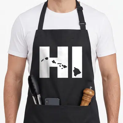 Map hawaii girl apron - White HI letters with grey Hawaiian island silhouettes overlaid across the front panel — shown on a black cotton canvas apron against a white background