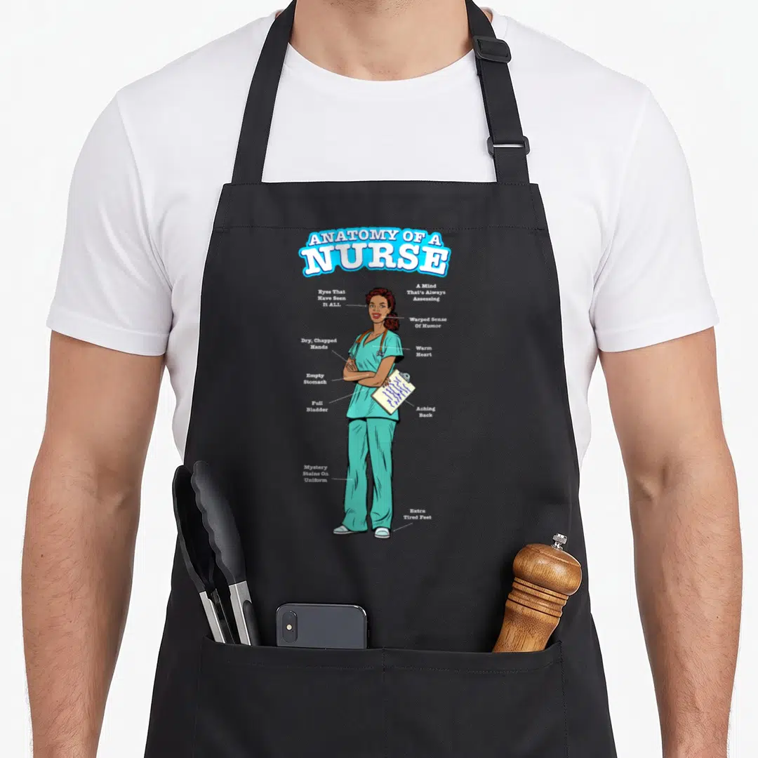 Poc anatomy apron - Cartoon nurse in teal scrubs with text labels pointing to dry chapped hands and full bladder — shown on a black cotton canvas apron against a white background