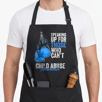 Boxing ribbon apron - Blue boxing gloves hanging beside speaking up for those who can't child abuse awareness text — shown on a black cotton canvas apron against a white background