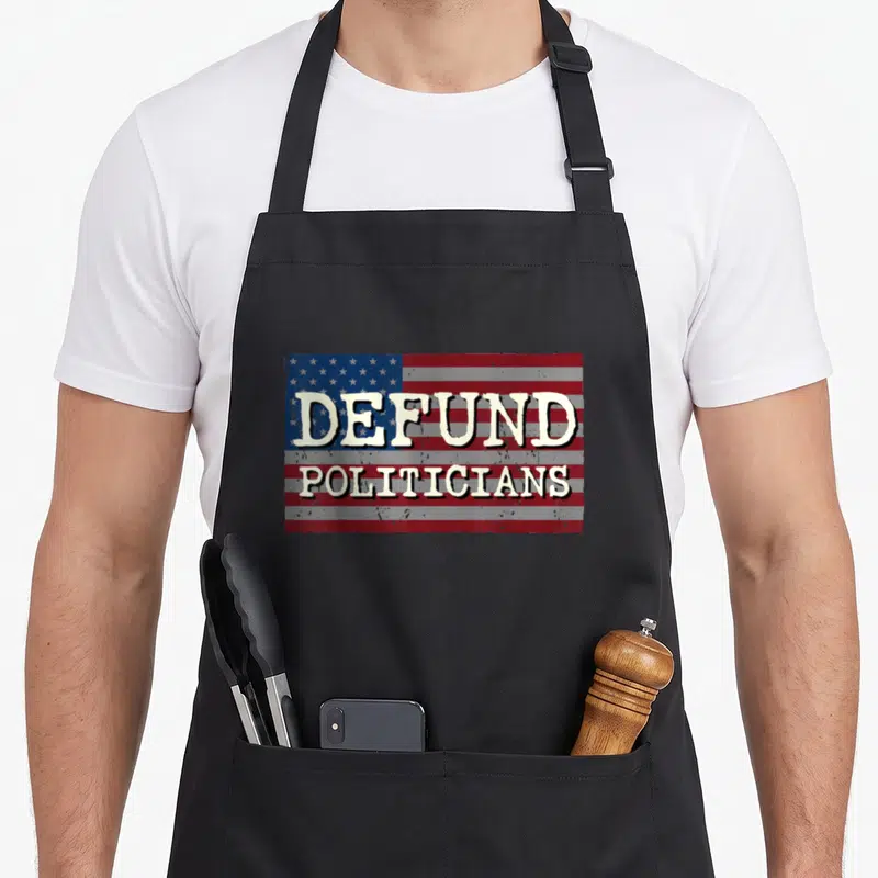 Politician political products online apron - Distressed US flag graphic with cream text reading DEFUND POLITICIANS — shown on a black cotton canvas apron against a white background