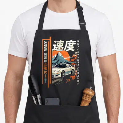 Japanese car apron - Retro white car, orange sun, blue mountain, Japanese kanji for speed, and vertical one way sign — shown on a black cotton canvas apron against a white background