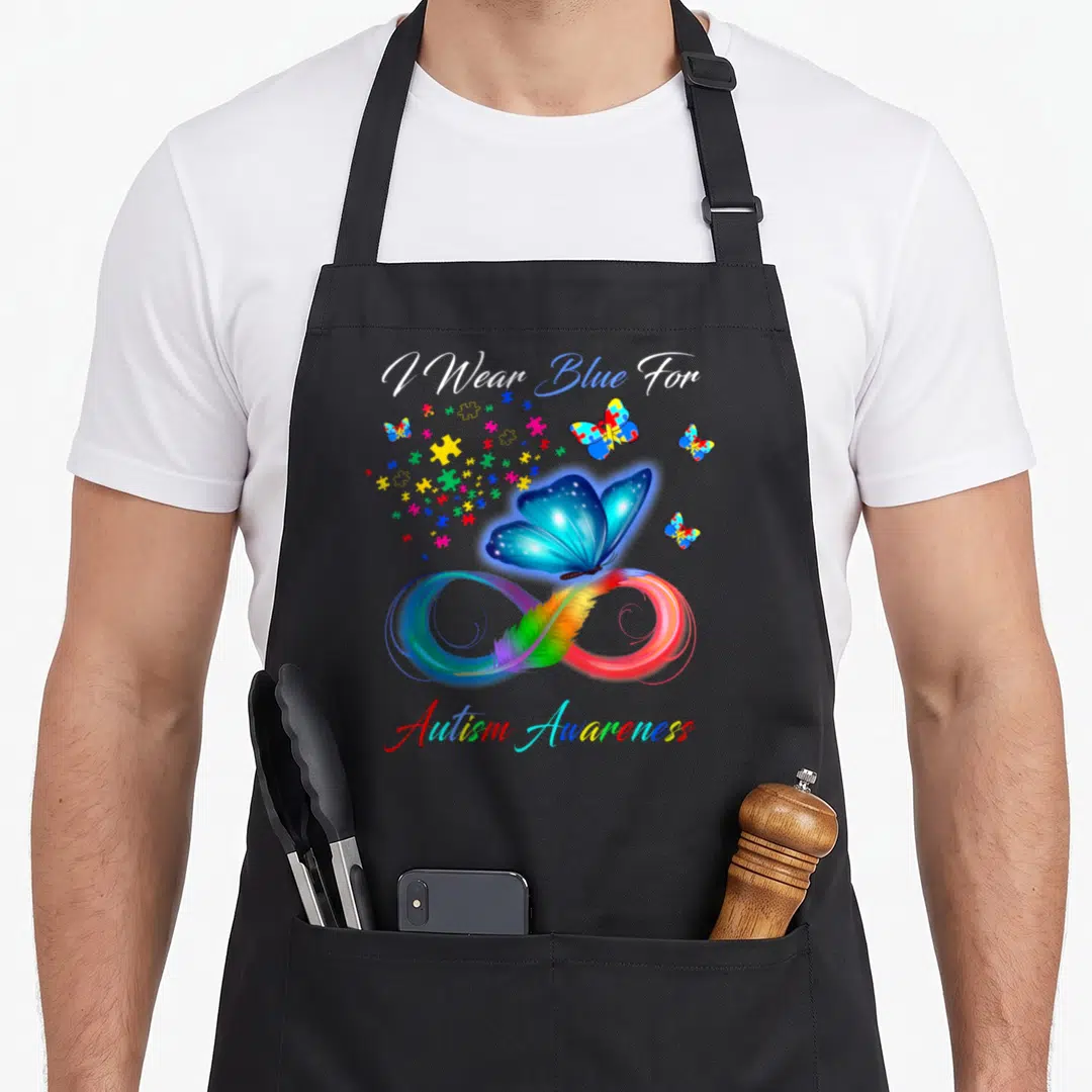 Blue anxiety awareness apron - I Wear Blue For Autism Awareness text with blue butterfly on rainbow infinity symbol — shown on a black cotton canvas apron against a white background