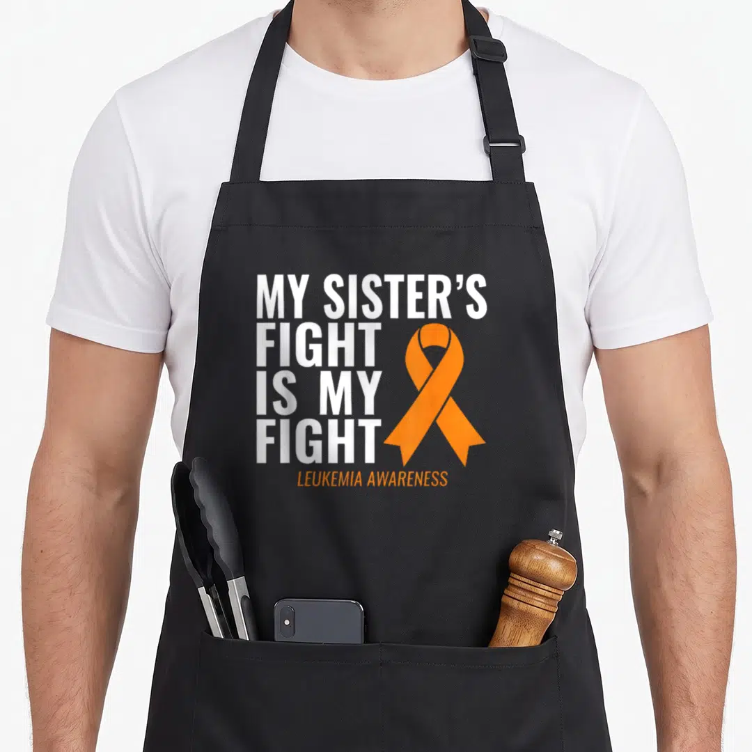 Fight nun apron - White stacked text My Sister's Fight is My Fight next to an orange awareness ribbon — shown on a black cotton canvas apron against a white background