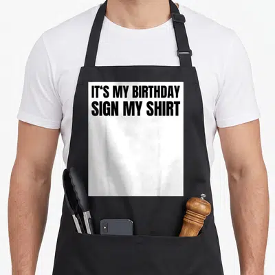 Ice birthday apron - Black text reading IT'S MY BIRTHDAY SIGN MY SHIRT on white background — shown on a black cotton canvas apron against a white background