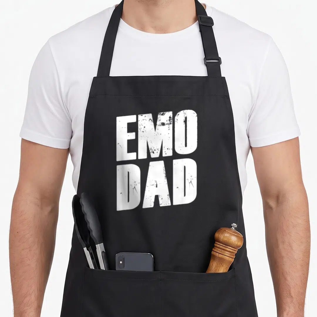 Punk gothic apron - White stacked EMO DAD text in distressed block font on black background — shown on a black cotton canvas apron against a white background