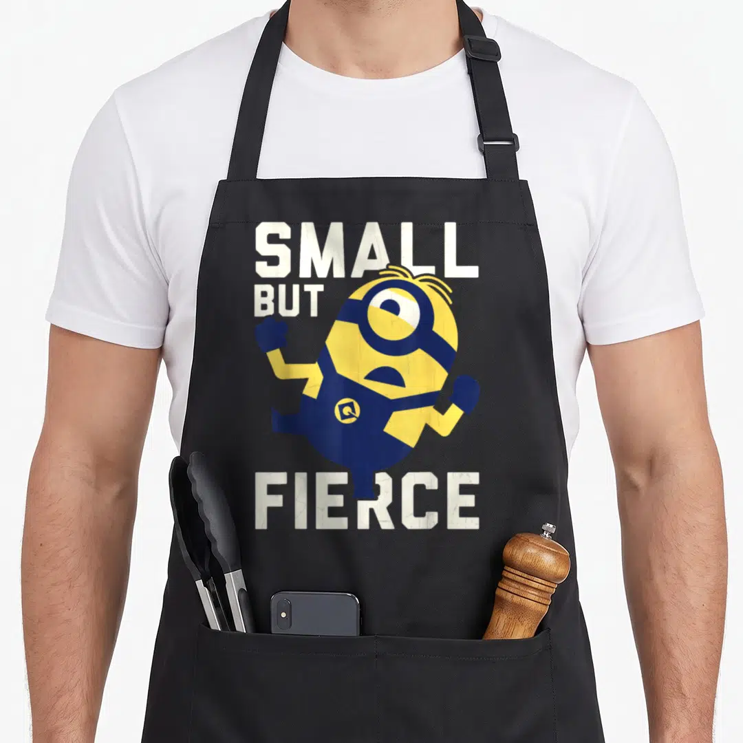 Despicable but apron - Yellow Minion running pose with white SMALL BUT FIERCE text — shown on a black cotton canvas apron against a white background