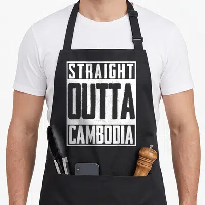 Cambodia pride apron - Stacked white and grey text reading straight outta cambodia inside a rectangular border — shown on a black cotton canvas apron against a white background