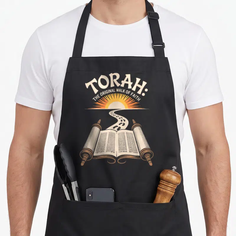 Torah walking apron - Arched text above orange sun and footprints leading to an open beige Torah scroll — shown on a black cotton canvas apron against a white background