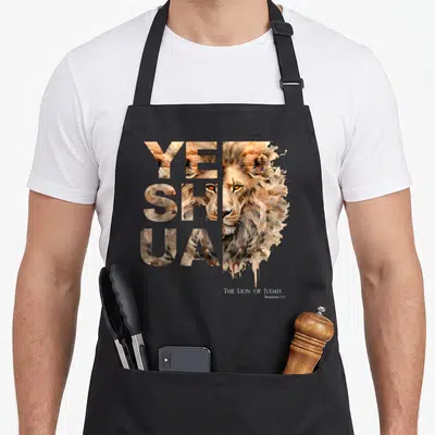 Yeshua lions apron - Realistic lion face with YESHUA text filled with fur texture and Revelation 5:5 verse below — shown on a black cotton canvas apron against a white background