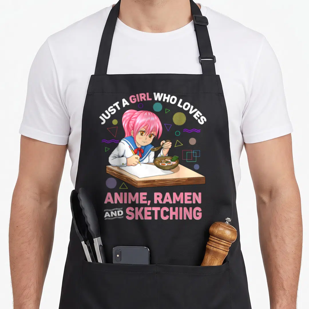 Retro ramen anime apron - Pink hair girl sketching ramen bowl with arching text and geometric shapes — shown on a black cotton canvas apron against a white background