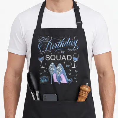 Birthday squad butterfly apron - Blue high heels, rhinestone SQUAD text, wine glasses, and butterflies — shown on a black cotton canvas apron against a white background