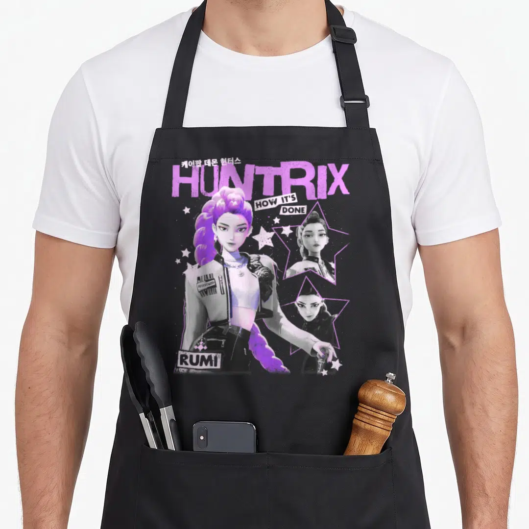 Poster trend apron - Huntrix Rumi poster art with purple hair, star frames, and How It's Done text — shown on a black cotton canvas apron against a white background