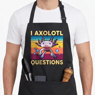 Question girls axolotl apron - Cartoon axolotl on tan pink blue orange stripes with I Axolotl Questions text — shown on a black cotton canvas apron against a white background