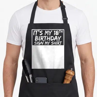 18th sign birthday apron - White text IT'S MY 18TH BIRTHDAY SIGN MY SHIRT on black bib apron — shown on a black cotton canvas apron against a white background