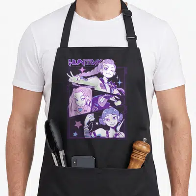 Animated hunter apron - Rumi Mira Zoey cartoon girls in diagonal panels with HUNTRX text and stars — shown on a black cotton canvas apron against a white background