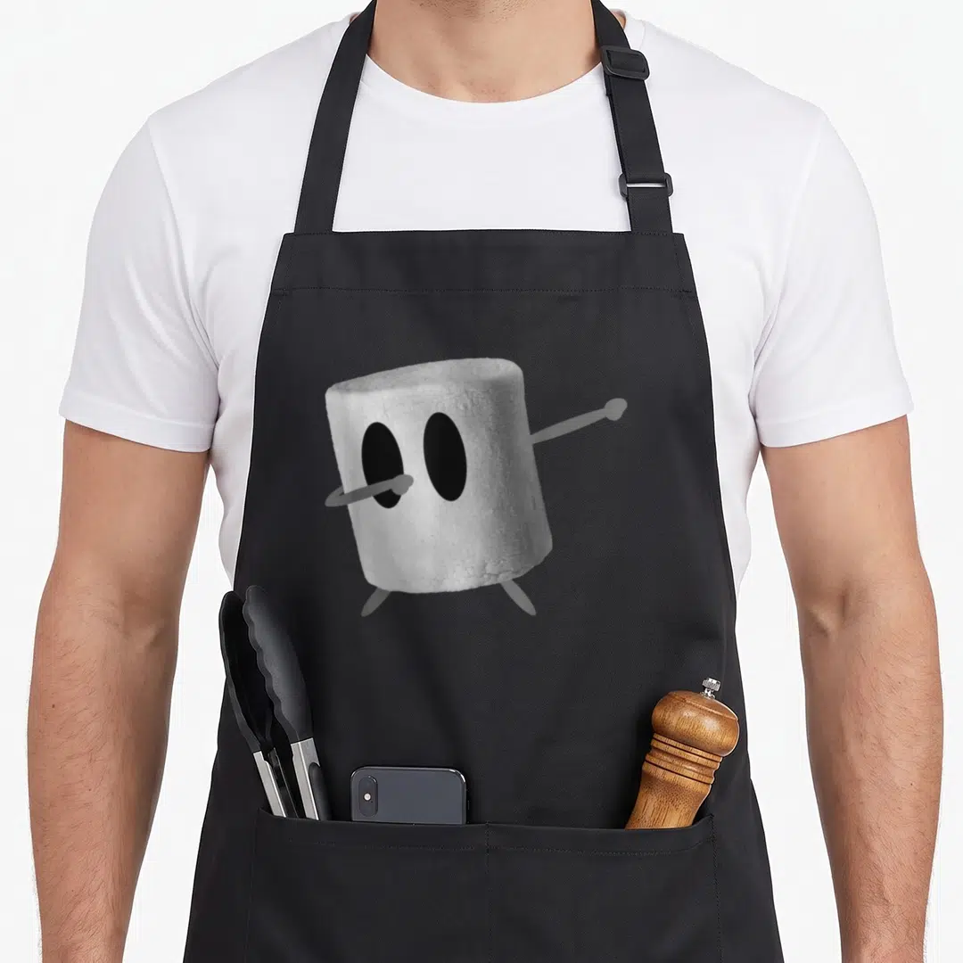 Dabbing marshmallow roasting apron - Anthropomorphic marshmallow character in a dab pose with black oval eyes and grey — shown on a black cotton canvas apron against a white background