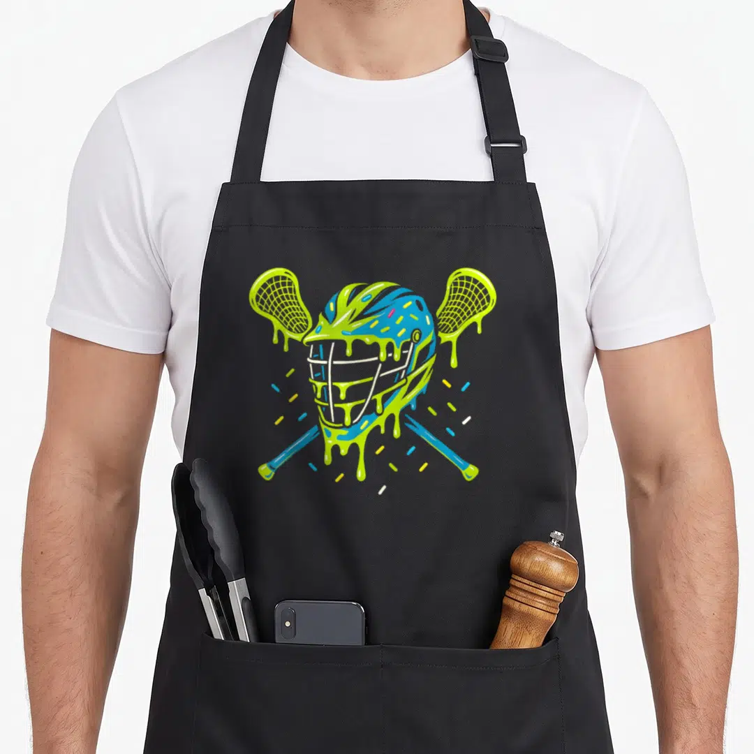 Lax ice cream apron - Cartoon blue helmet with lime drips and sprinkles between two crossed sticks — shown on a black cotton canvas apron against a white background