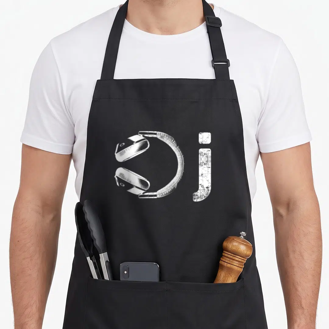 Headphone novelty apron - White headphones graphic next to a large lowercase letter j — shown on a black cotton canvas apron against a white background