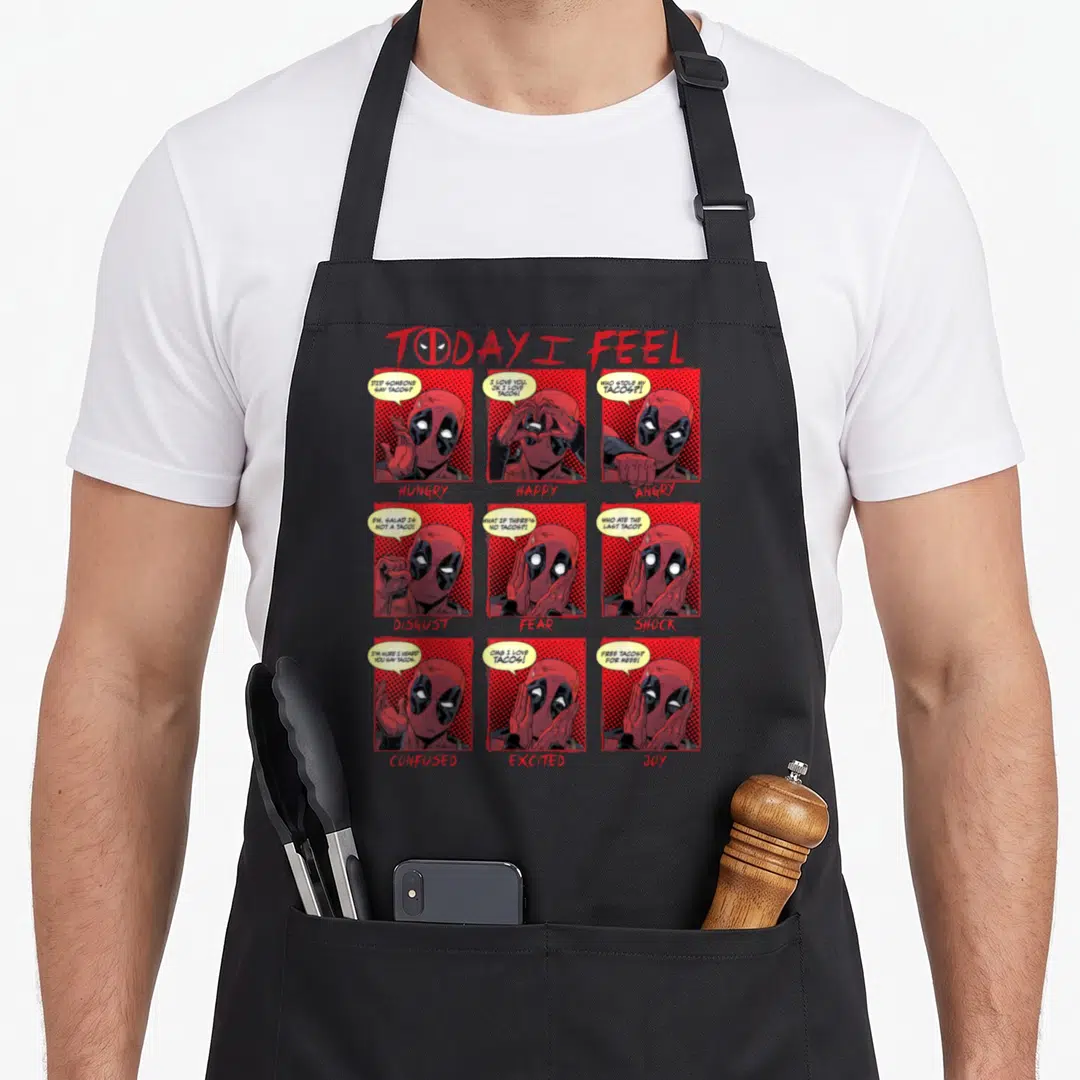 Today comics apron - Deadpool comic grid with speech bubbles about tacos and mood labels in red and black — shown on a black cotton canvas apron against a white background
