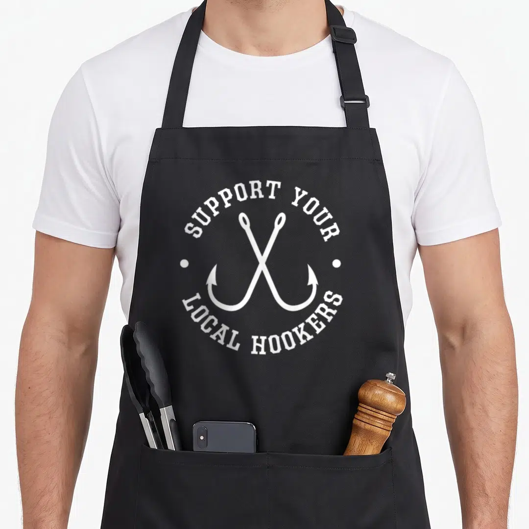 Local fishing aprons - White crossed fishing hooks with arched text Support Your Local Hookers and side dots — shown on a black cotton canvas apron against a white background