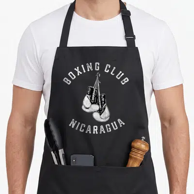 Nicaragua gloves and apron - Two hanging boxing gloves with arched Boxing Club Nicaragua text in distressed white — shown on a black cotton canvas apron against a white background