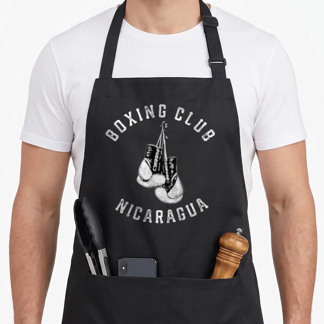 Nicaragua gloves and apron - Two hanging boxing gloves with arched Boxing Club Nicaragua text in distressed white — shown on a black cotton canvas apron against a white background