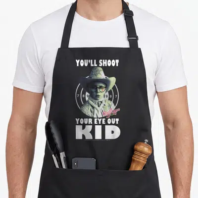 Ralphie christmas apron - Boy in cowboy hat over target with text You'll Shoot Your Eye Out Kid — shown on a black cotton canvas apron against a white background