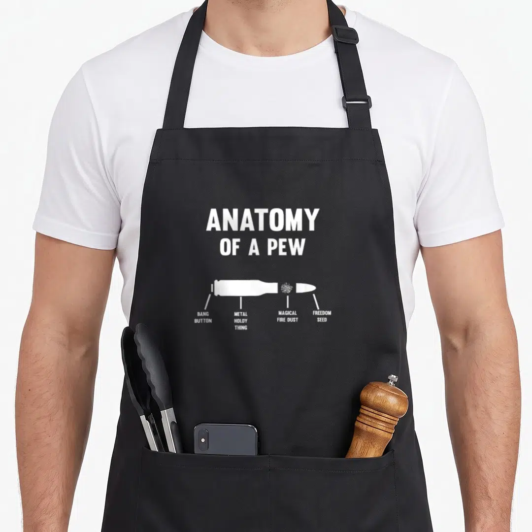 Anatomy parts of an apron - White bullet diagram labeled Bang Button Metal Holdy Thing Magical Fire Dust Freedom Seed — shown on a black cotton canvas apron against a white background
