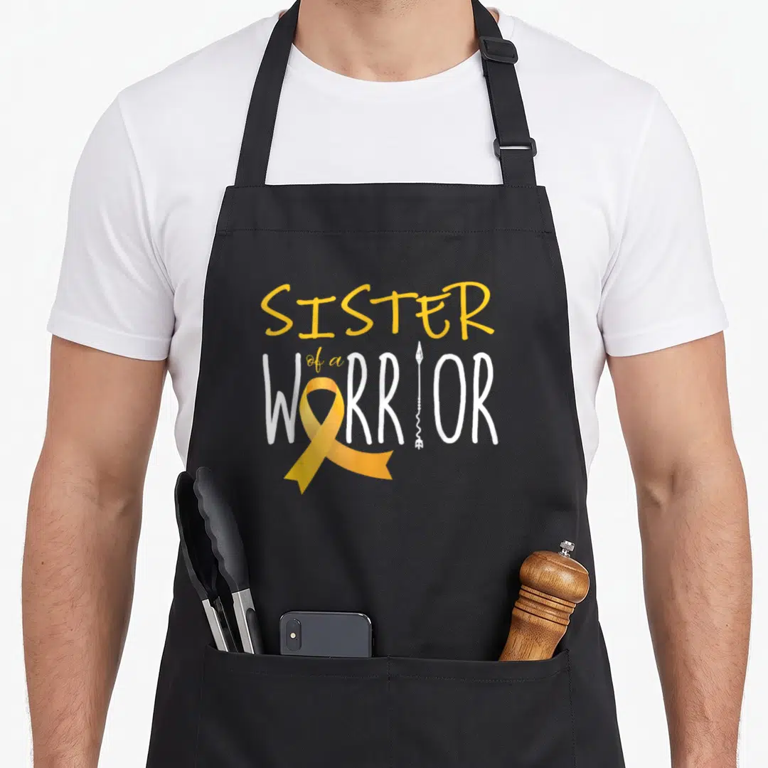 Awareness cancer girl apron - Yellow ribbon and white arrow integrated into SISTER of a WARRIOR typography — shown on a black cotton canvas apron against a white background