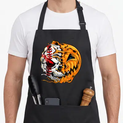 Baseball player halloween apron - Cartoon pumpkin skull with red baseball stitching and orange flame details — shown on a black cotton canvas apron against a white background