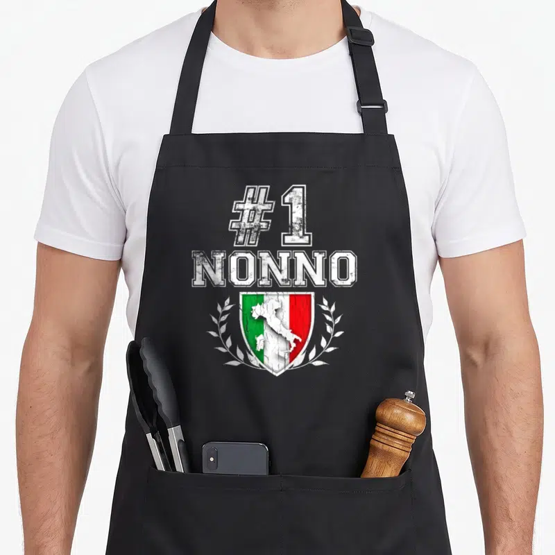 Number italian apron - #1 NONNO text above Italian flag shield with map and laurel wreath in distressed style — shown on a black cotton canvas apron against a white background