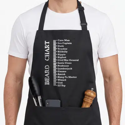 Measurement beard apron - Vertical white distressed text reading BEARD CHART next to a scale listing beard types — shown on a black cotton canvas apron against a white background