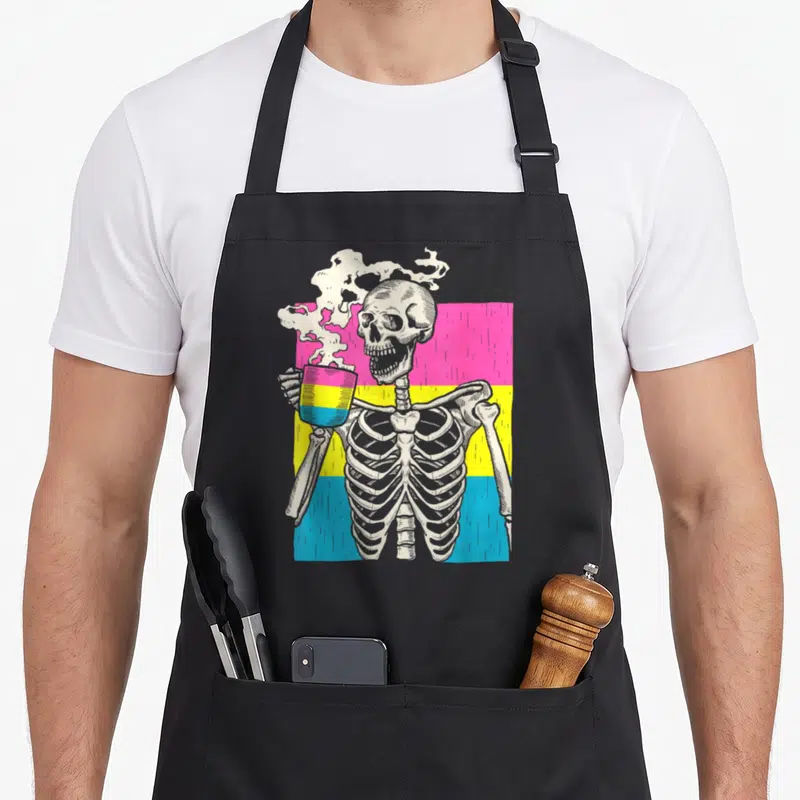 Pride skeleton apron - Cartoon skeleton holding striped mug in front of pink yellow blue stripes — shown on a black cotton canvas apron against a white background