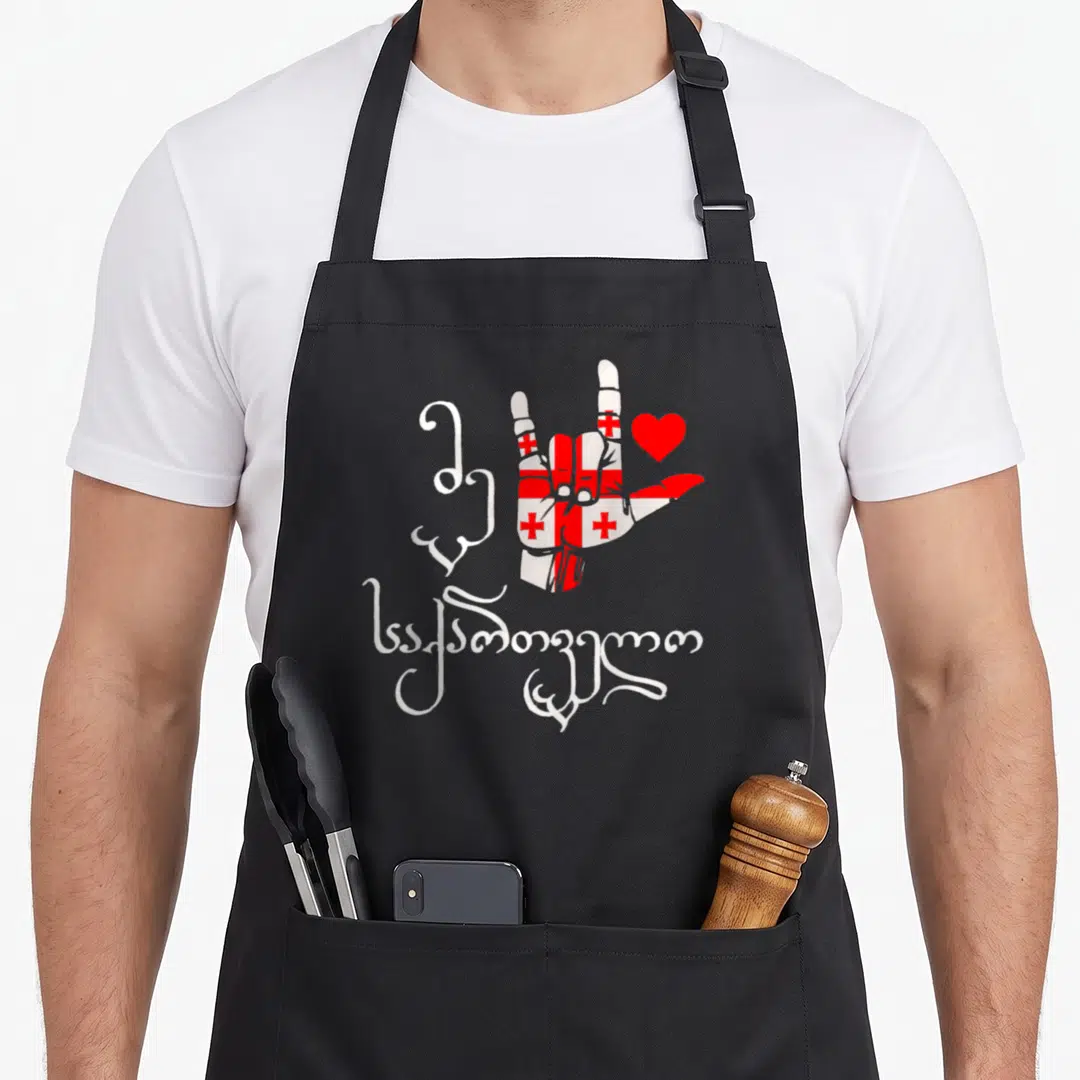 Georgia patriotic apron - Hand filled with red and white flag pattern next to a red heart and white Mkhedruli script — shown on a black cotton canvas apron against a white background