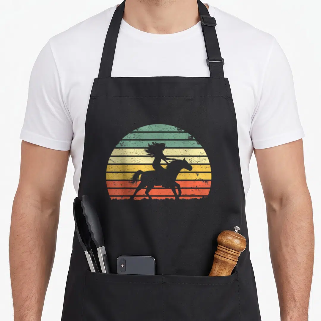 Horse texas apron - Retro silhouette of woman riding horse against striped sunset in green yellow orange red grey — shown on a black cotton canvas apron against a white background