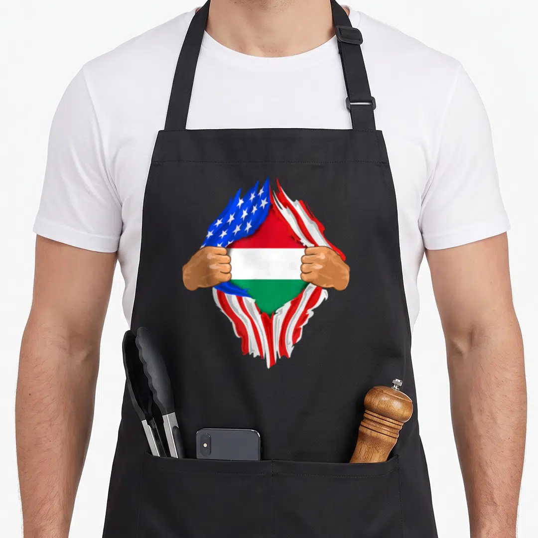 Hungarian blood apron - Two brown hands tear red white and blue USA flag revealing red white green Hungarian flag — shown on a black cotton canvas apron against a white background