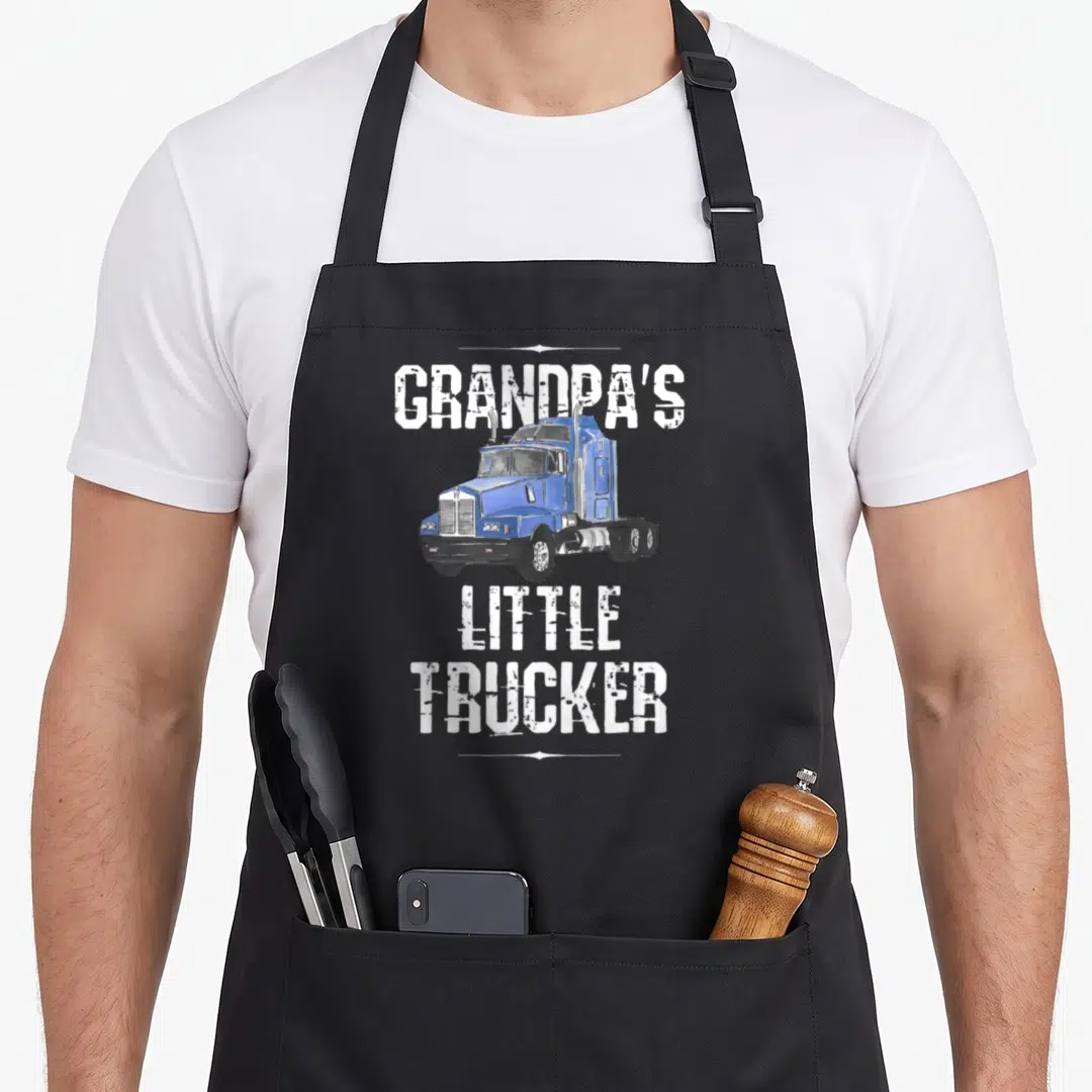 Grandpas semi truck apron - Blue cartoon semi-truck centered between white GRANDPA'S LITTLE TRUCKER text — shown on a black cotton canvas apron against a white background