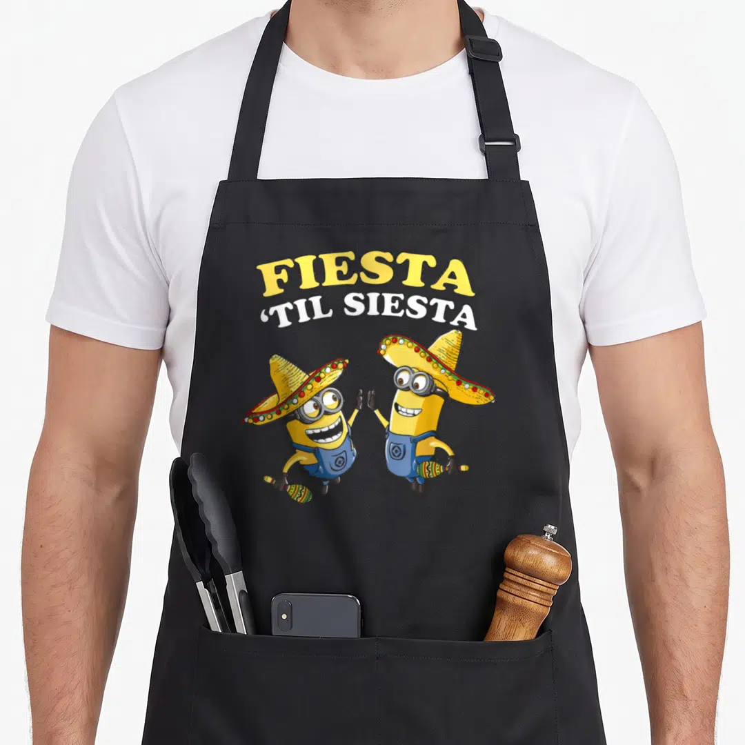Fiesta general apron - Two minions in sombreros holding maracas under FIESTA ‘TIL SIESTA text — shown on a black cotton canvas apron against a white background