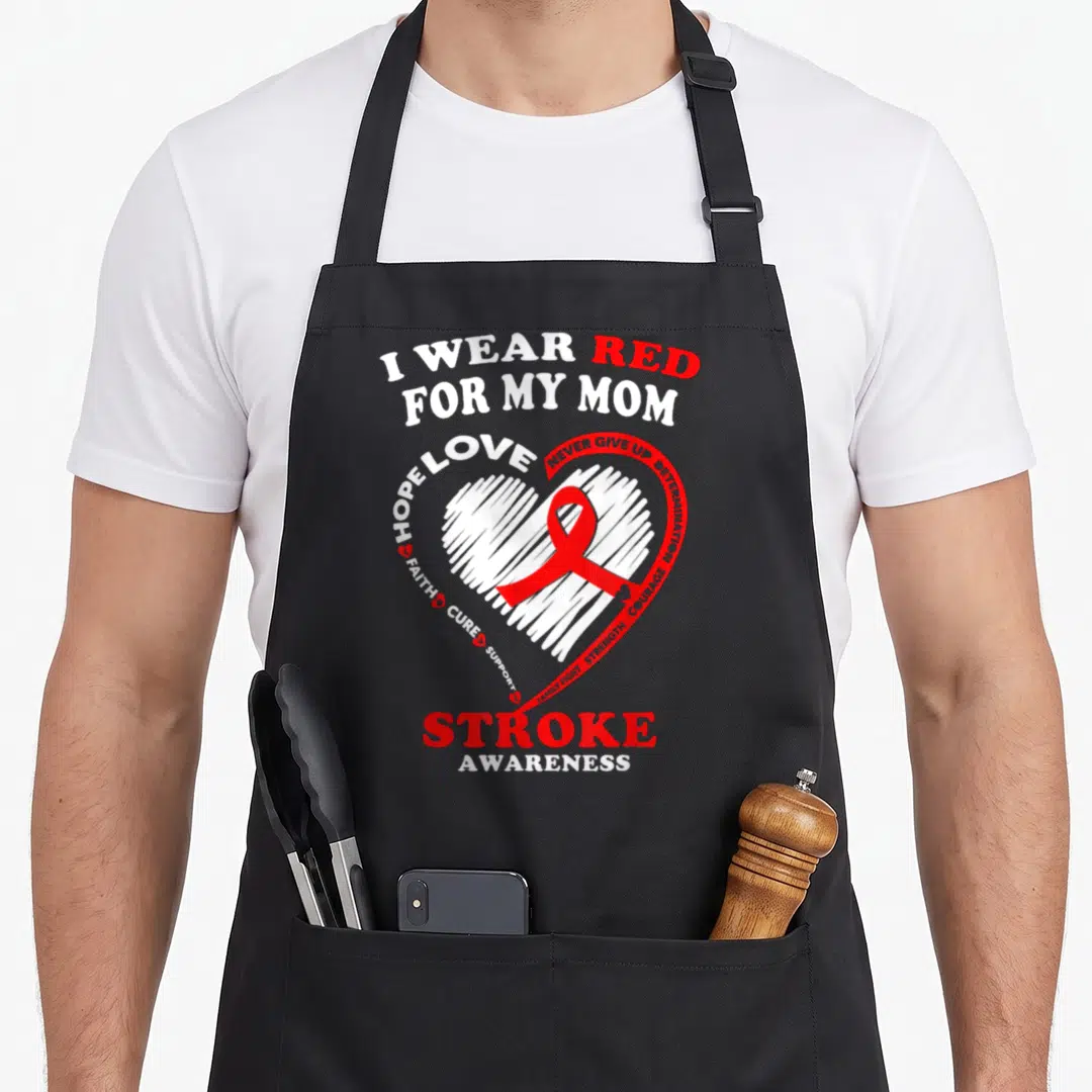 Stroke pink ribbon apron - Red and white heart with ribbon and text I Wear Red For My Mom Stroke Awareness — shown on a black cotton canvas apron against a white background