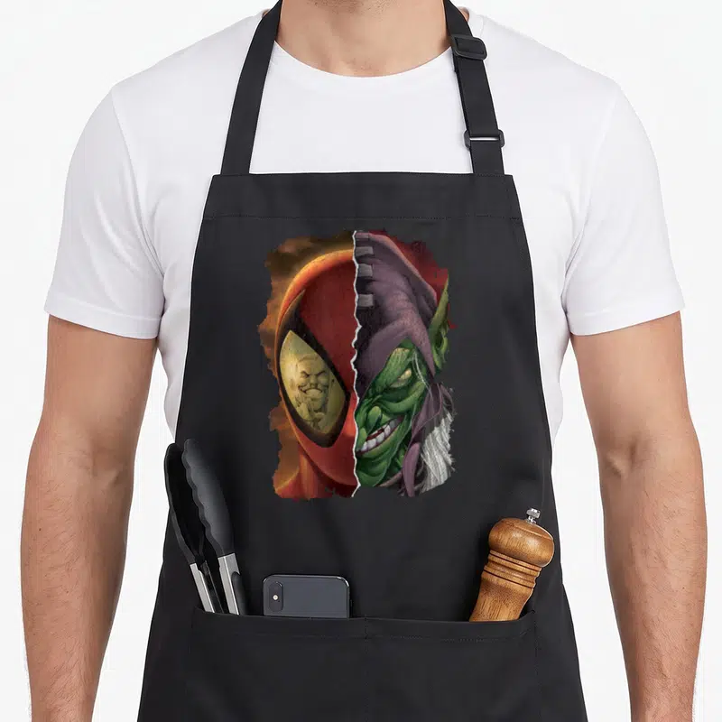 Funny goblin apron - Split face red mask green face purple hood realistic rain effect — shown on a black cotton canvas apron against a white background