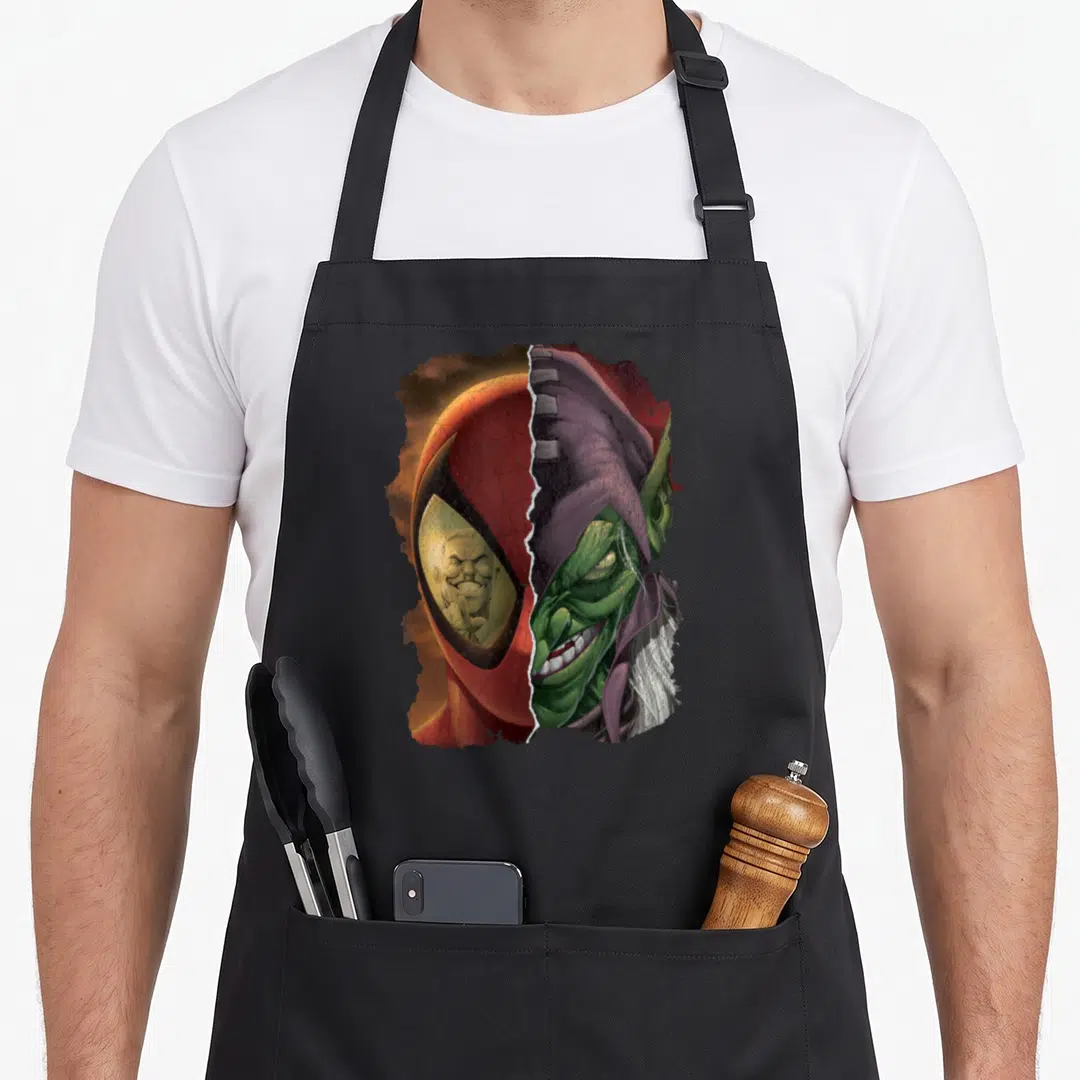 Funny goblin apron - Split face red mask green face purple hood realistic rain effect — shown on a black cotton canvas apron against a white background
