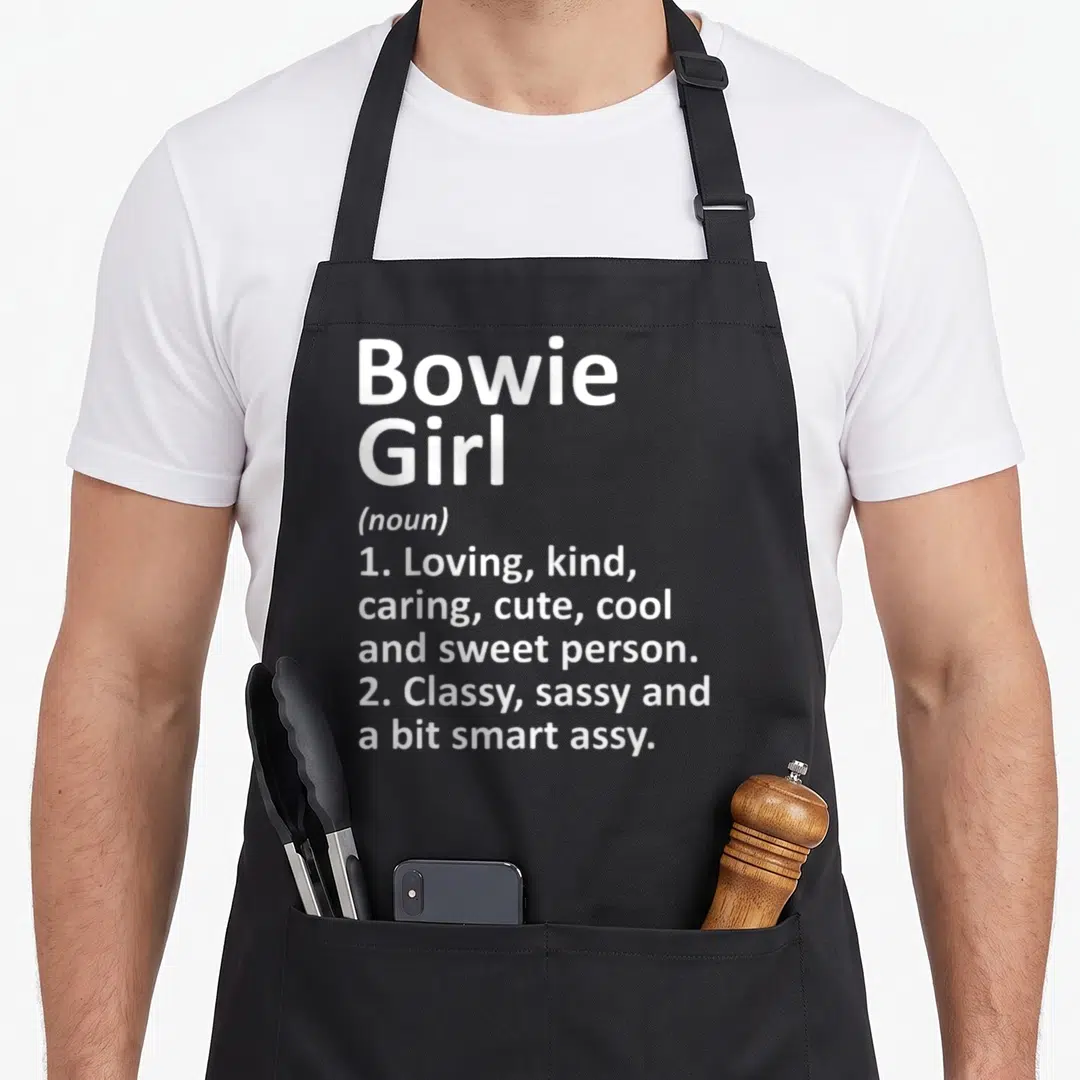 Bowie texas apron - White typography defining Bowie Girl as a loving, sassy person — shown on a black cotton canvas apron against a white background