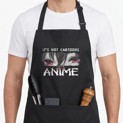 Animation anime character apron - Red anime eyes between white text reading Its Not Cartoons and Its Anime — shown on a black cotton canvas apron against a white background