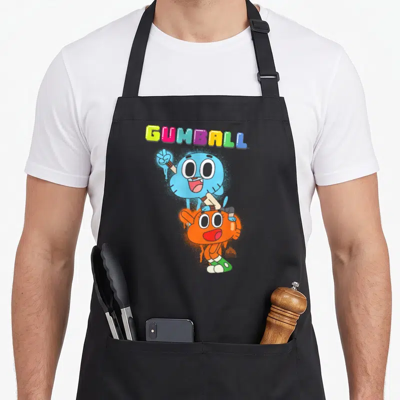 Amazing black cat apron - Multi-colored GUMBALL text above a blue cat standing behind an orange fish in a cartoon style — shown on a black cotton canvas apron against a white background